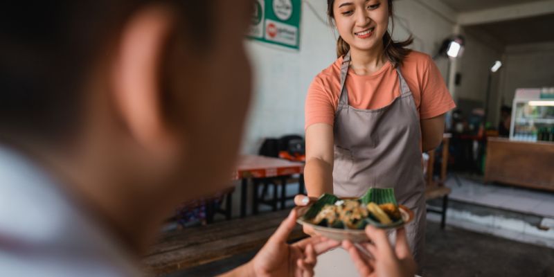 A Filipino staff serving food to a customer