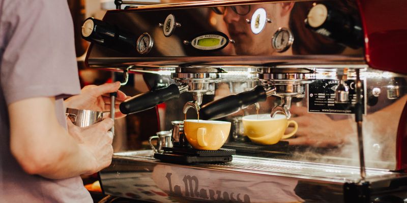 A Filipino barista making coffee at a café