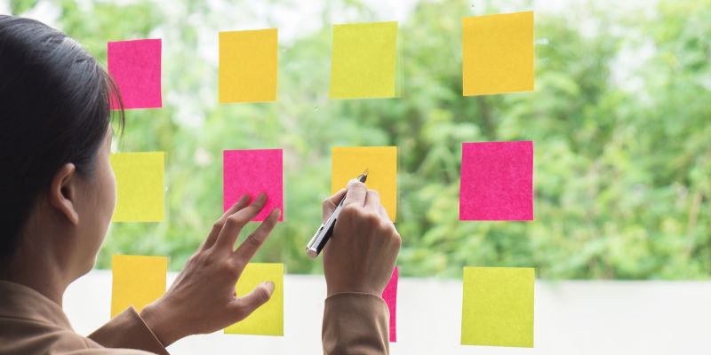 A Filipino woman writing down goals on post its