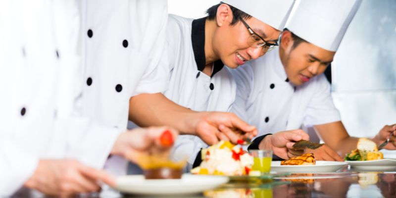 Filipino chefs happily preparing food for their restaurant