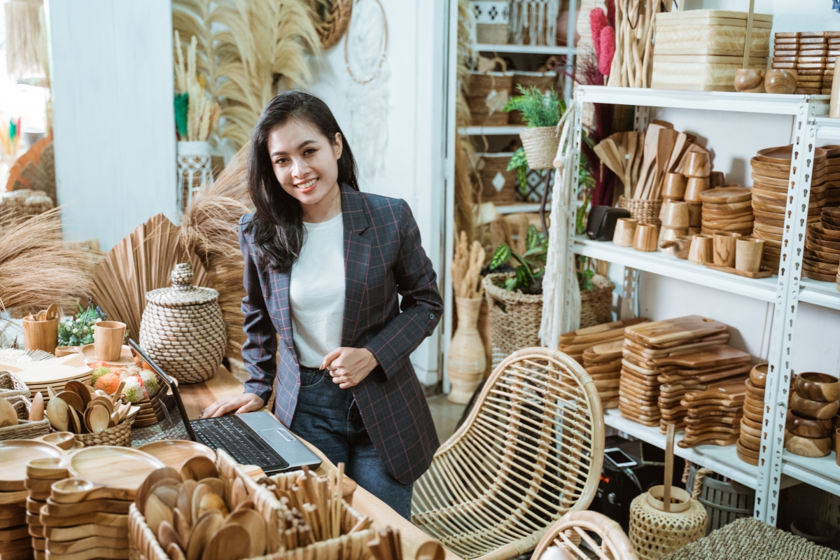 Asian business owner standing in front of a table