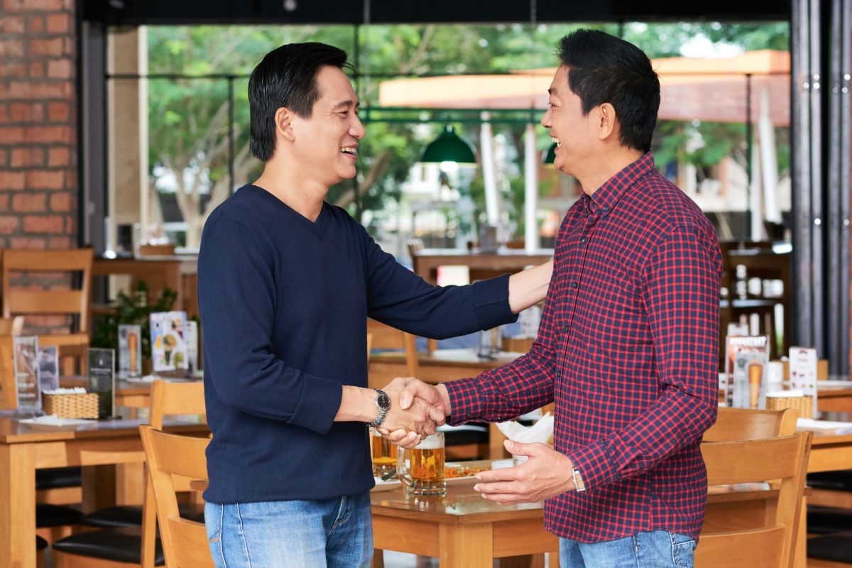 Two business owners shaking hands in a restaurant