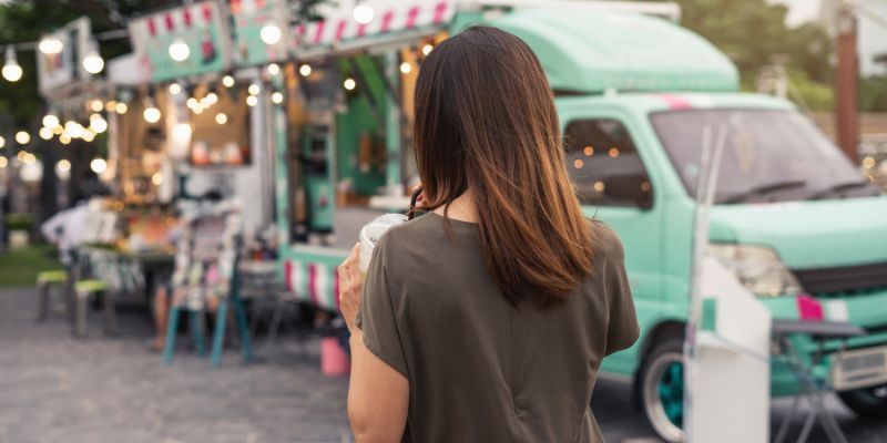 A Filipino woman enjoying a drink at a Sunday market.