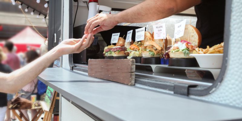 A customer paying for her food in a food truck