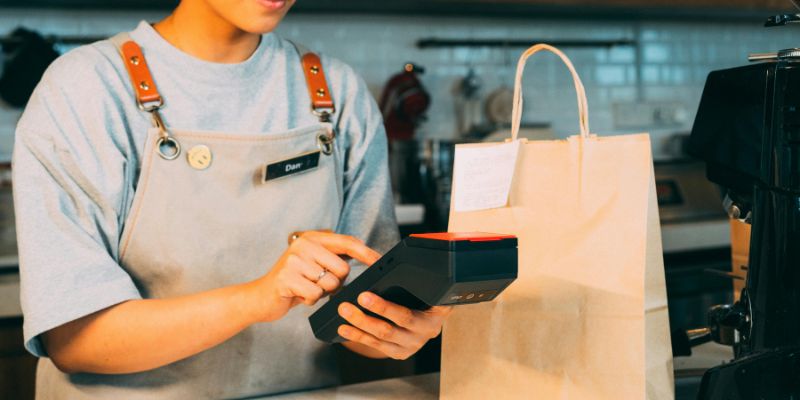 A Filipino F&B staff member getting payment from a customer