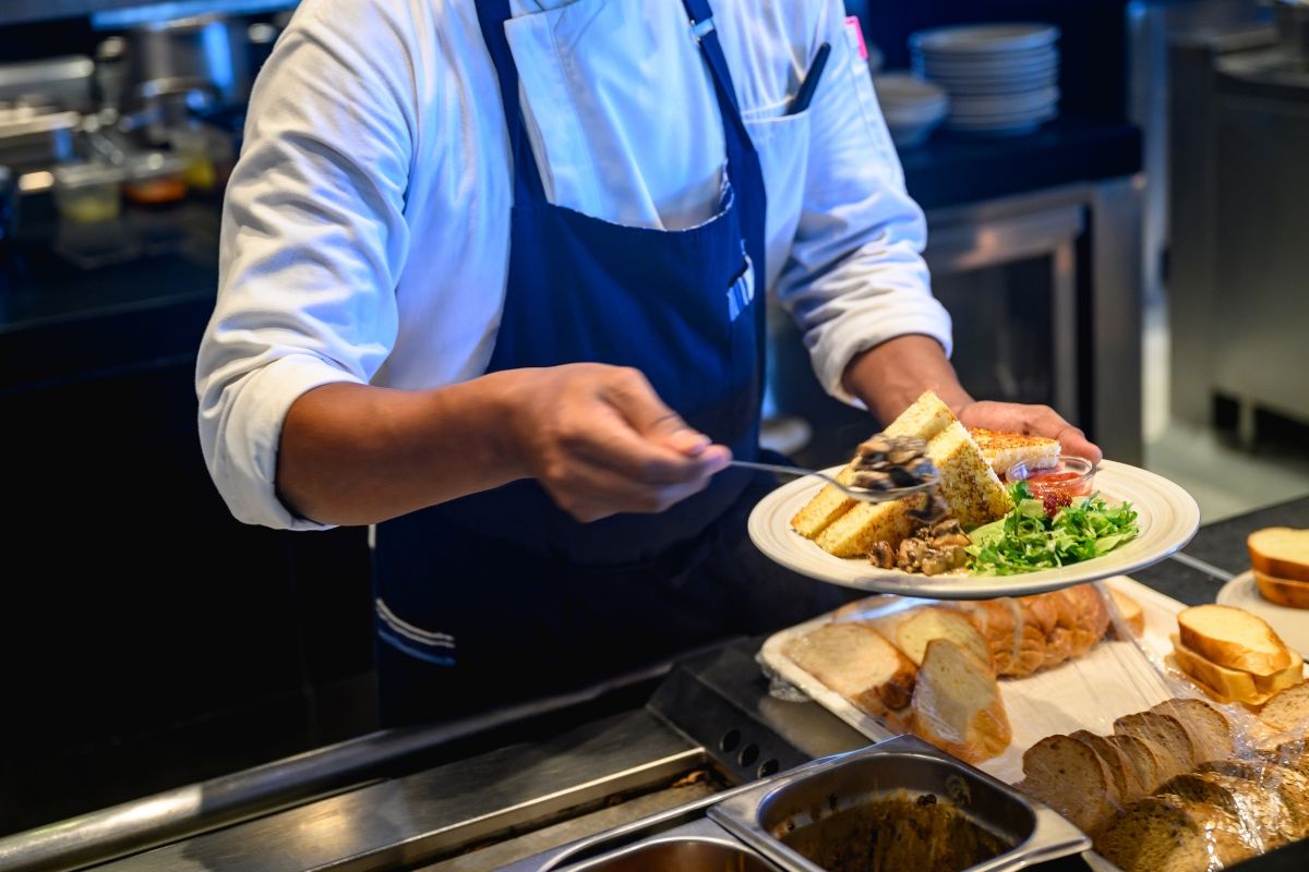 A Filipino F&B staff serving food to a customer