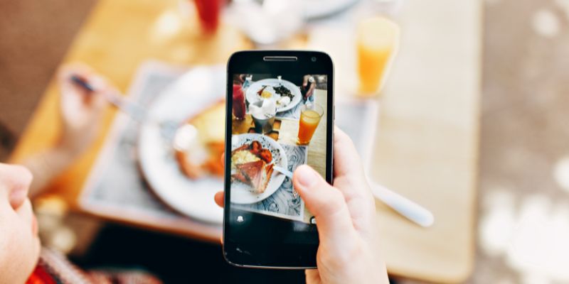 A Filipino SME owner taking photo of food