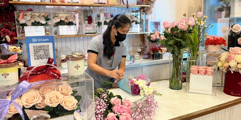 A Boxed Blossoms staff arranging flowers