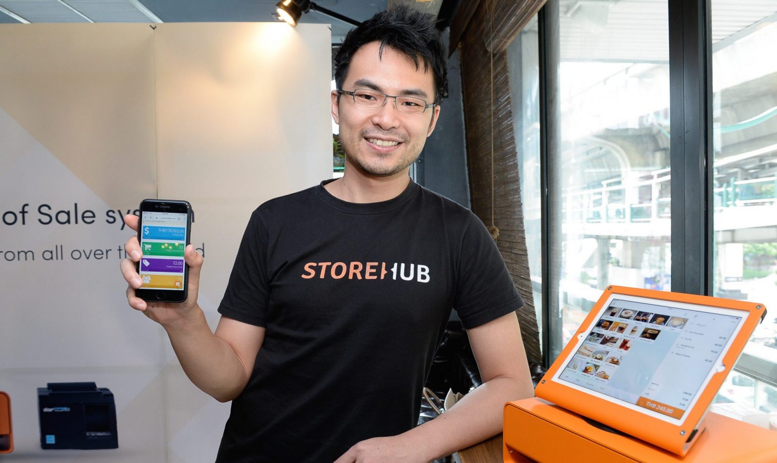 StoreHub CEO holding phone