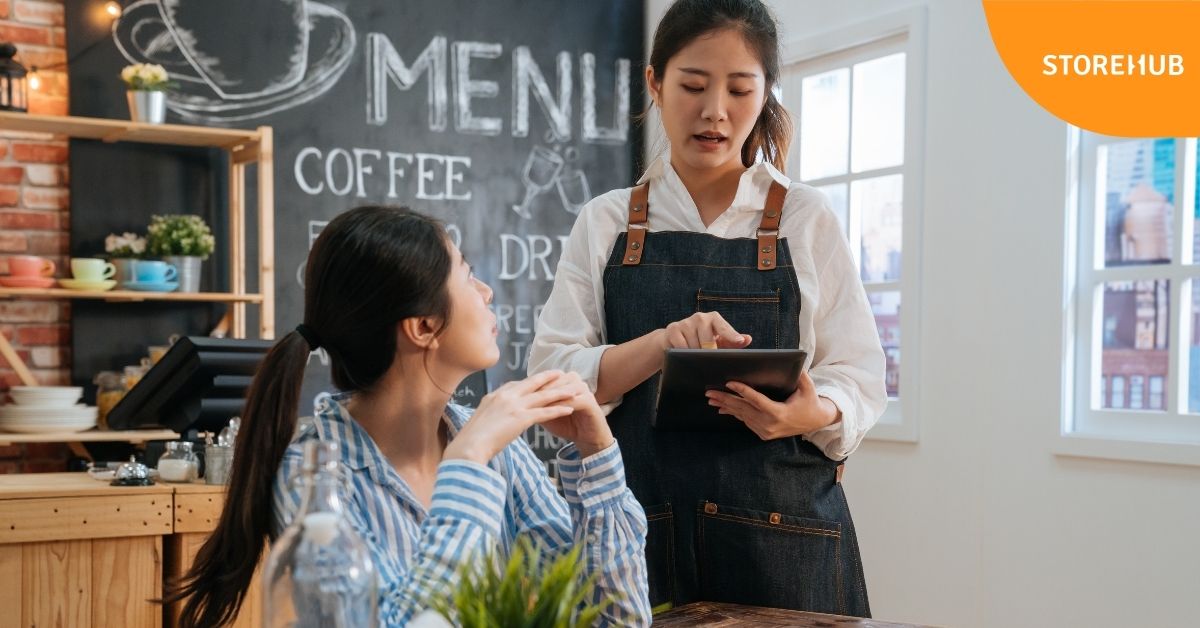 Waitress taking customer's order in a cafe