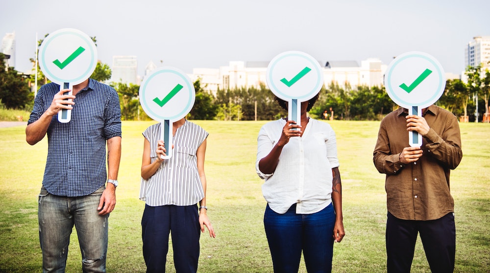 people holding check mark signs