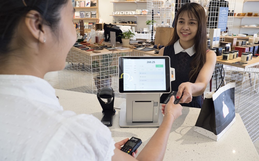 woman paying for item at cash register with credit card