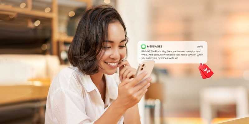 Asian girl smiling happily upon receiving a promotional text message via SMS marketing