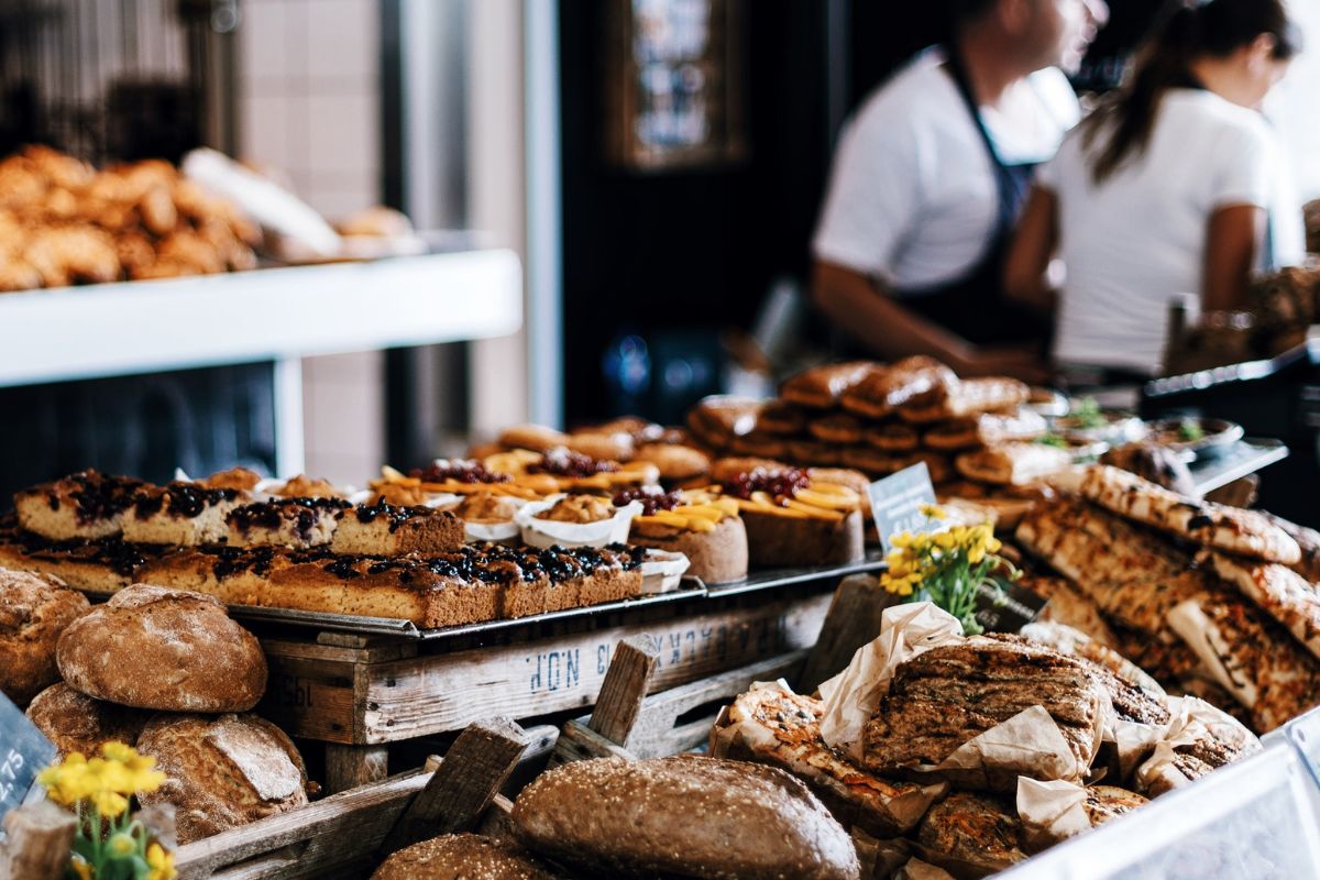 A spread of delicious baked goods with the bakery owners serving a customer