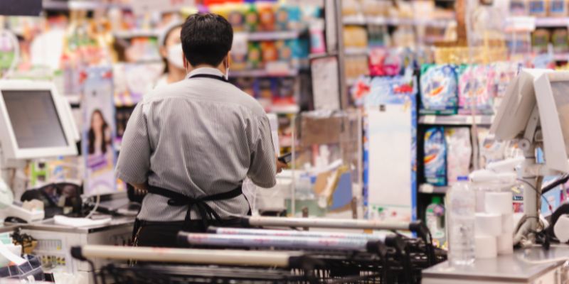 Grocery store staff serving a customer