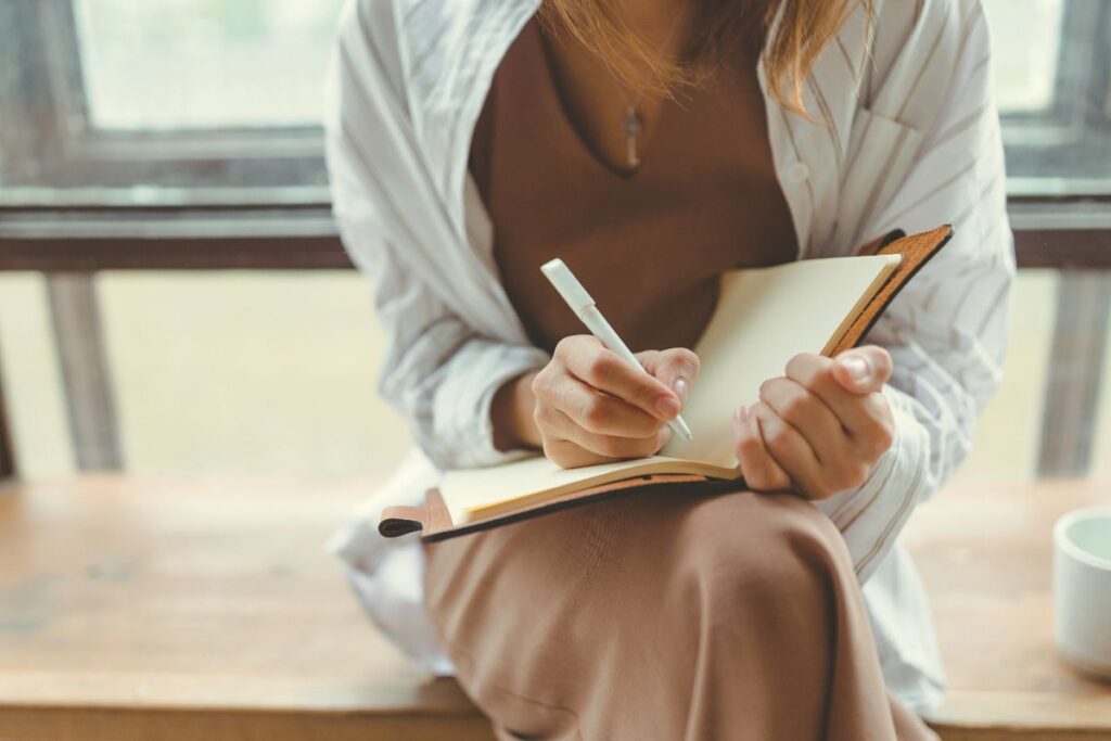 A Malaysian business owner writing on her notebook