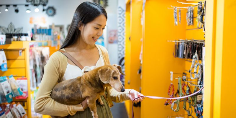 A woman with her dog in a pet shop