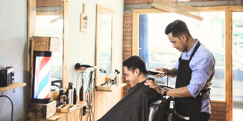 A client getting a haircut at a barber shop in Klang Valley